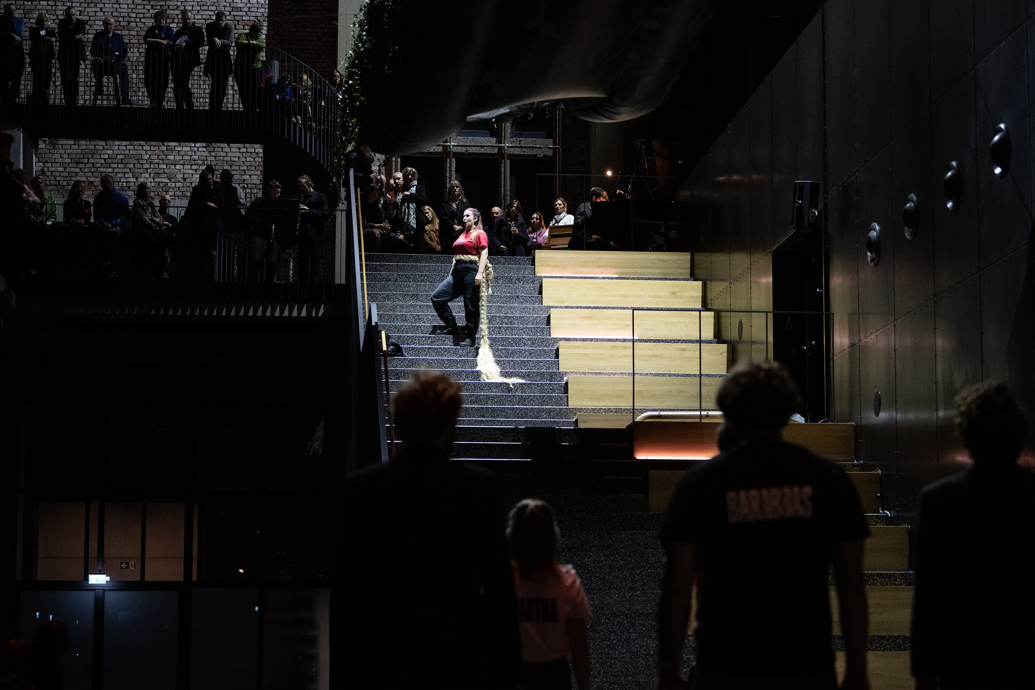 Maria (Rusnė Tušlaitė) steht im Scheinwerferlicht auf der Treppe