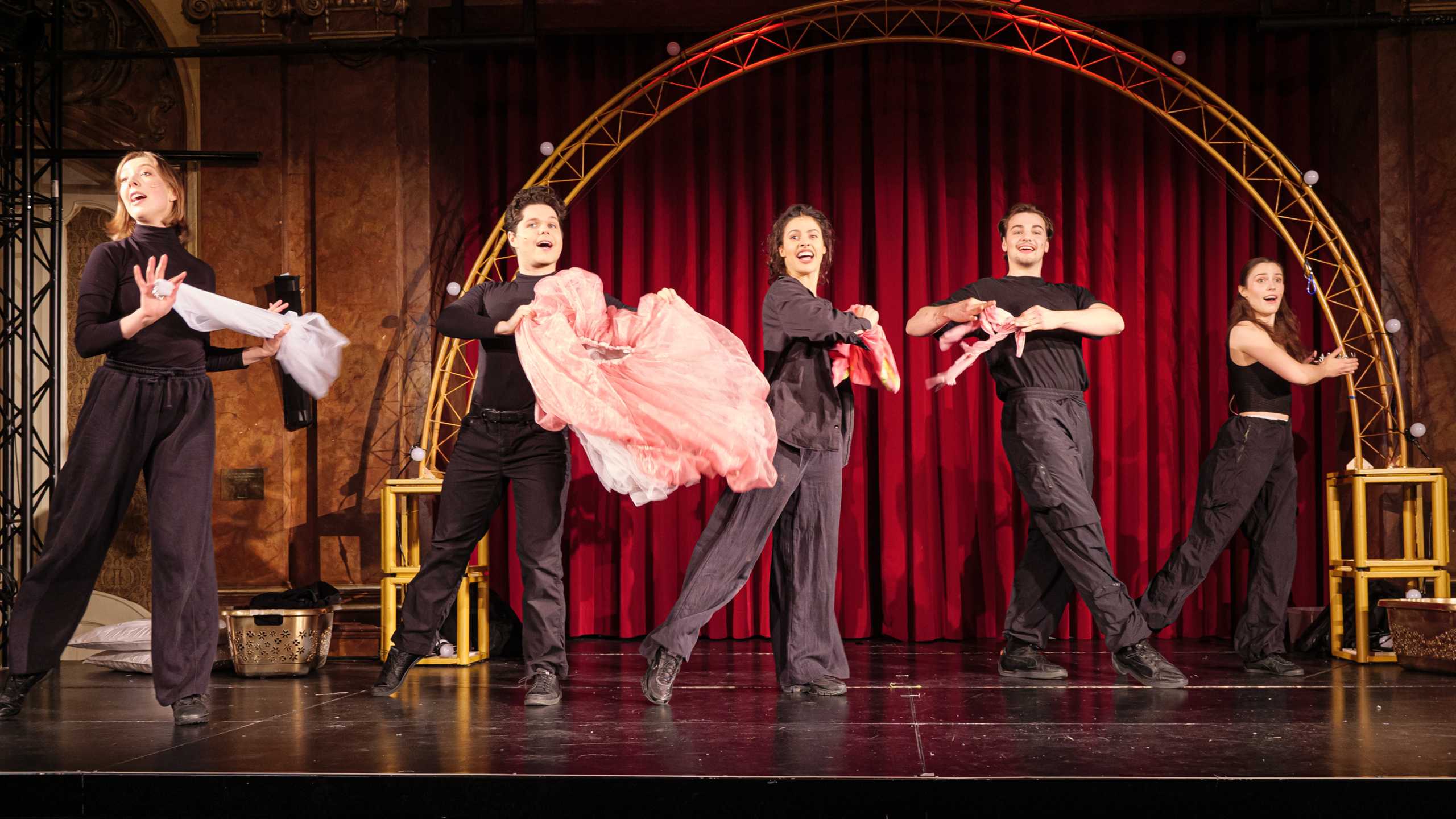 Esra Bücker, Nico Burbes, Valentina Pohl, David Weinert und Valeria Purzer in schwarzer Kleidung mit Prinzessinkostümstücken in den Händne auf der Bühne des Silbersaals im Deutschen Theater