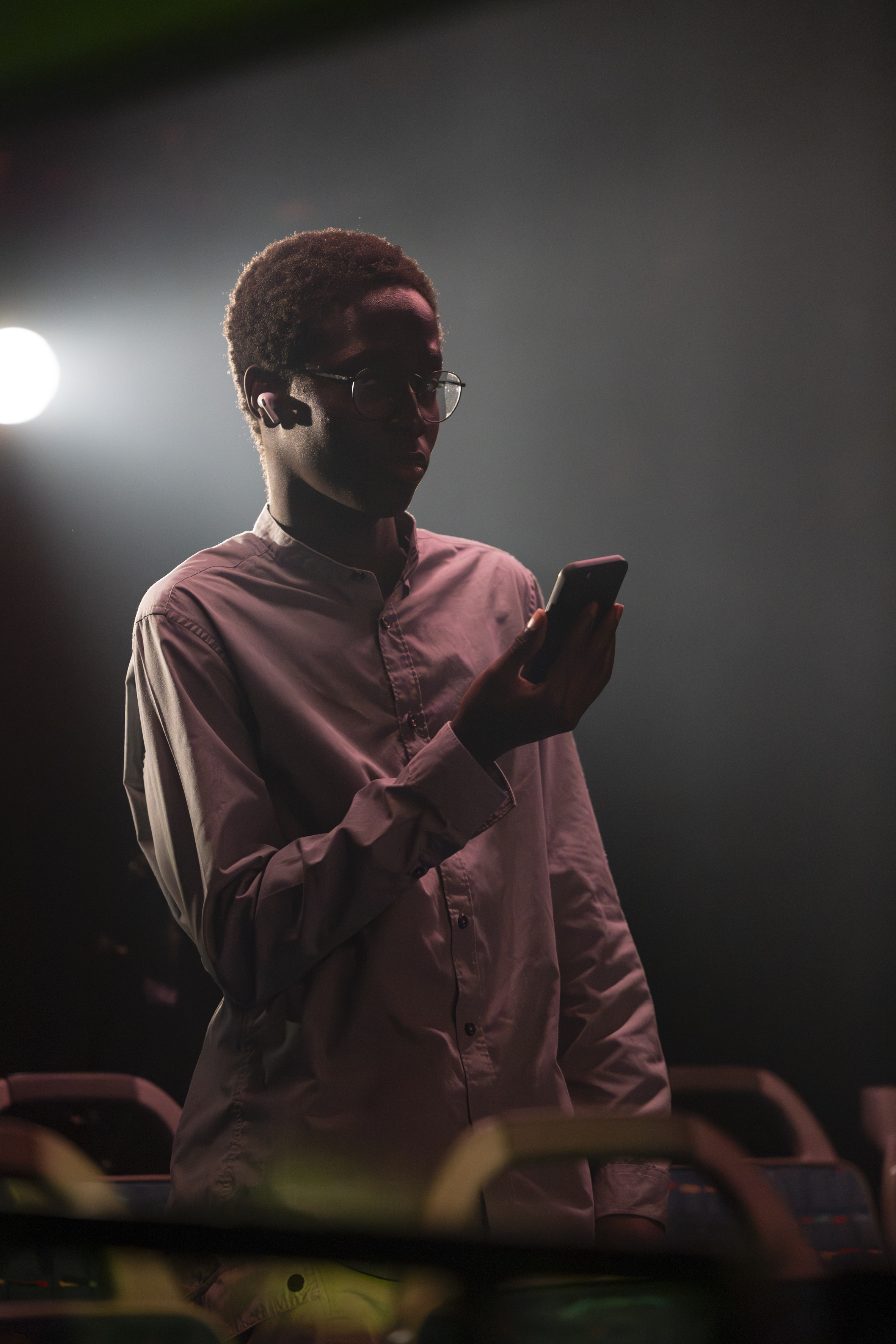 Eine Figur von vorne, stehend im Bus, schaut auf ihr Handy.