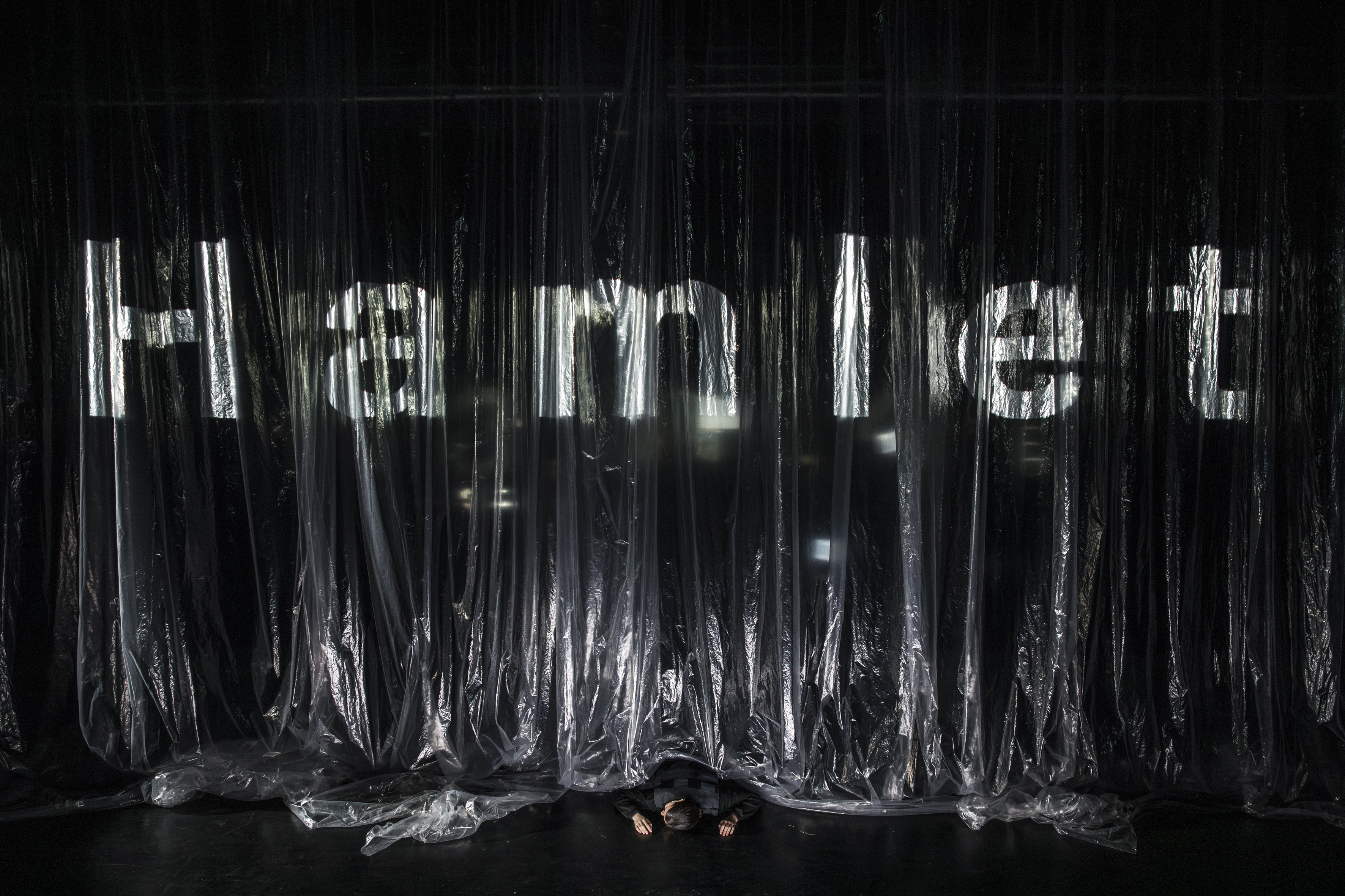 Ein Theatervorhang aus durchsichtiger Folie, auf den das Wort 